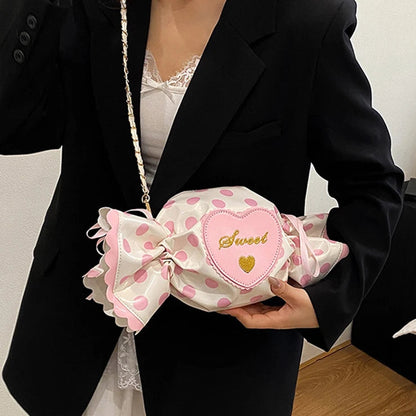 Person holding a pink polka dot bag with a heart-shaped patch.