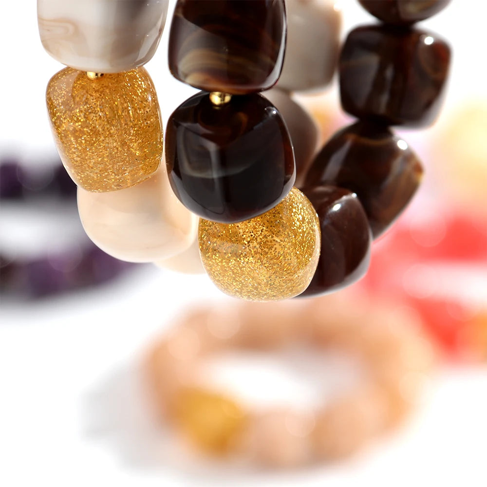 Close-up of a beaded bracelet with gold and brown beads on a blurred background