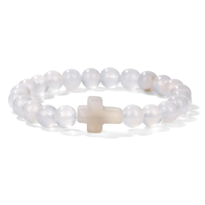 Pearl bracelet with a beige cross on a white background