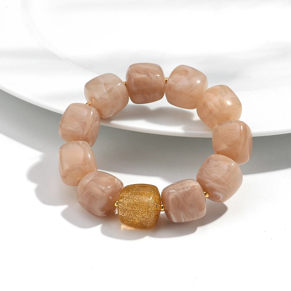Bracelet with pink beads and a gold accent on a white background