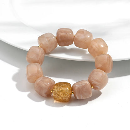 Bracelet with pink beads and a gold accent on a white background
