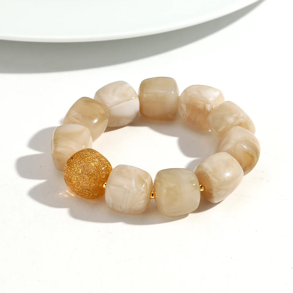 Beige beaded bracelet with a gold accent on a white background
