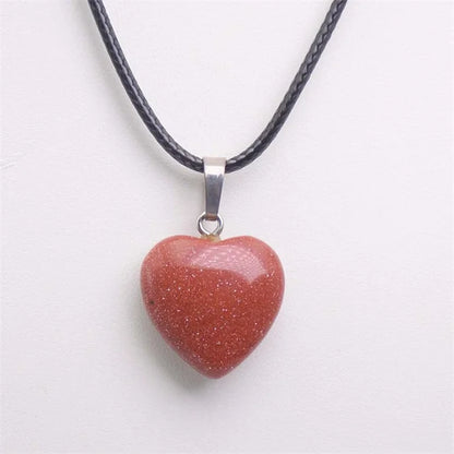 Heart-shaped stone pendant on a black cord against a white background