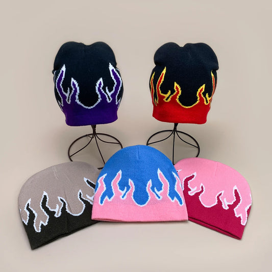 Five colourful beanies with flame designs on a beige background