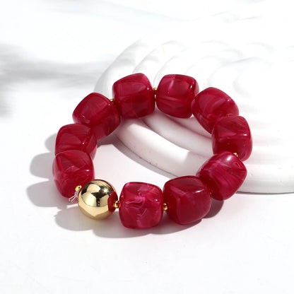 Red beaded bracelet with a gold accent on a white background