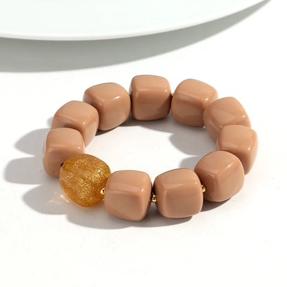 Beige bracelet with a gold bead on a white background