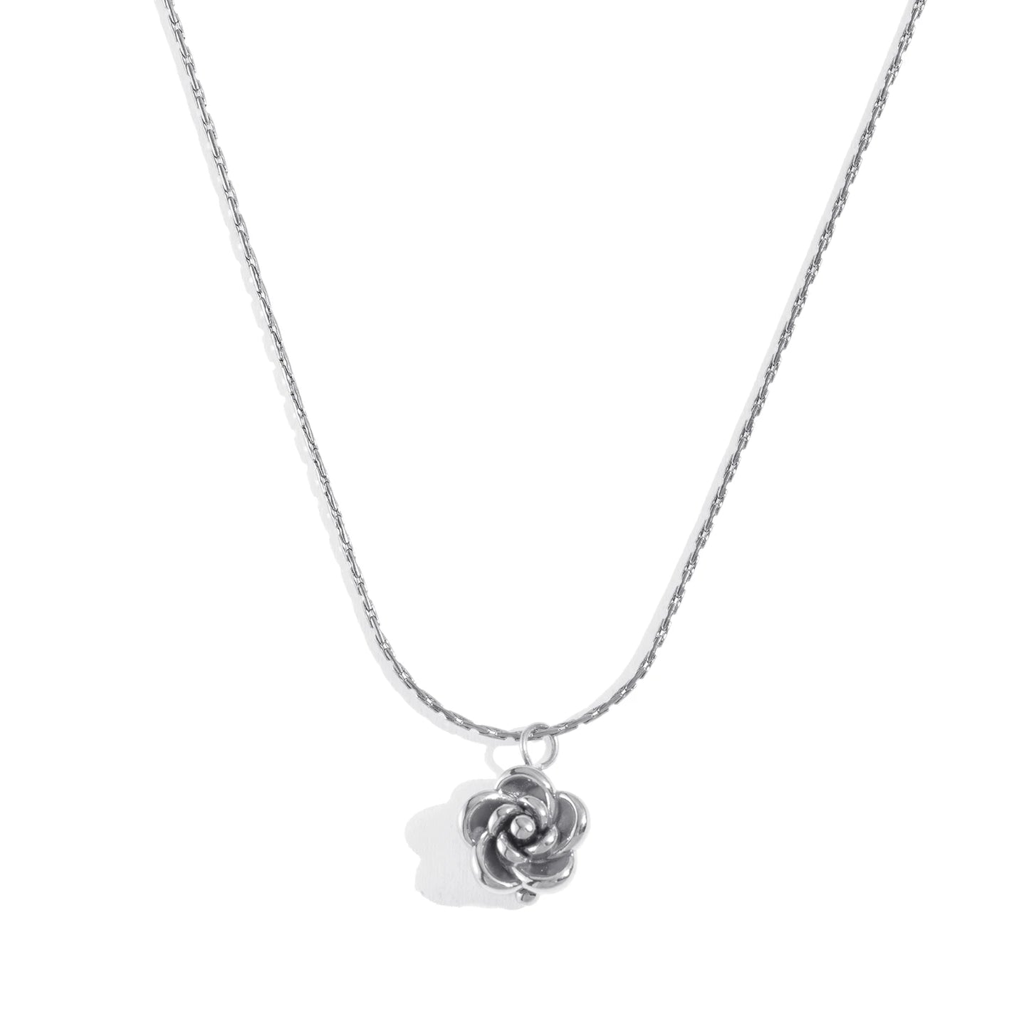 Silver rose-shaped pendant on a chain against a white background