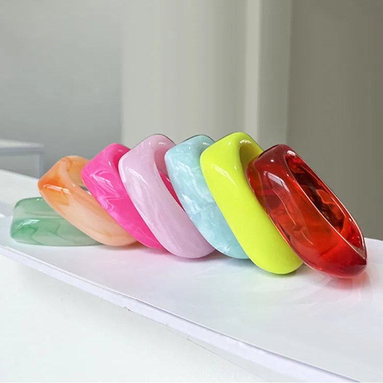 Colourful bangles on a white surface with a neutral background