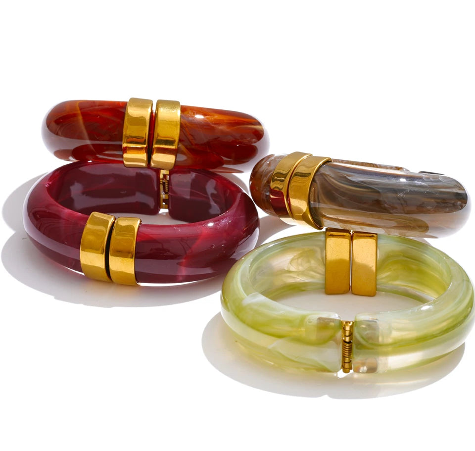 Set of colourful bangles with gold accents on a white background