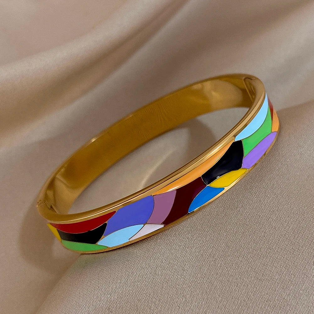 Colourful bracelet with gold band on a beige fabric background