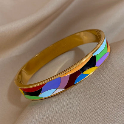 Colourful bracelet with gold band on a beige fabric background