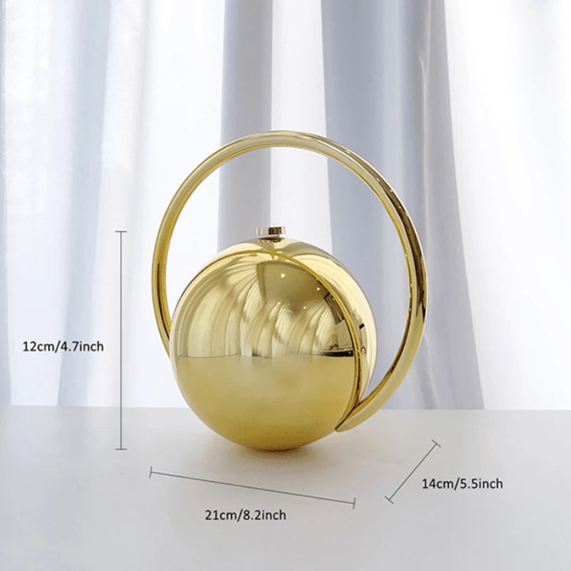 Gold spherical clutch bag with handle and measurements on a white background