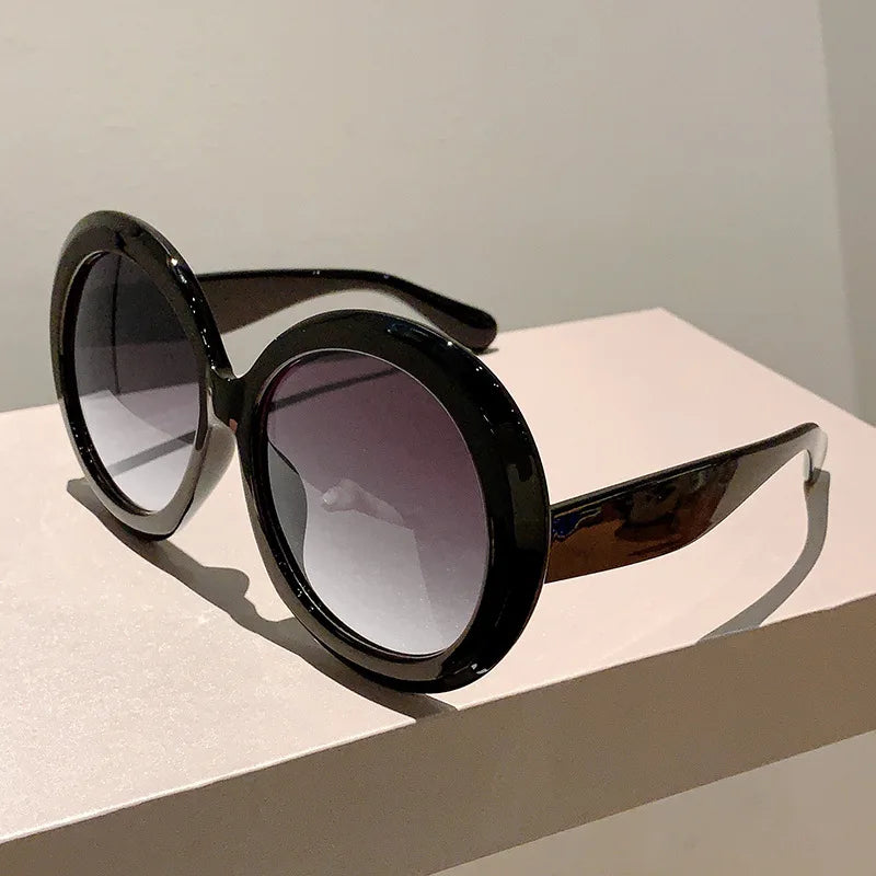 Black sunglasses with gradient lenses on a light surface