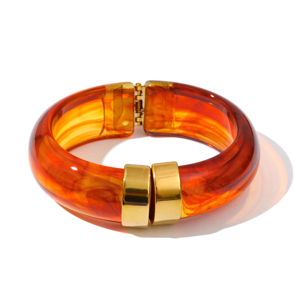 Orange and red bangle with gold clasp on a white background