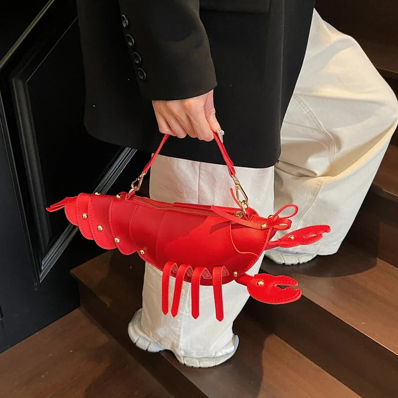 Person holding a red lobster-shaped handbag indoors.