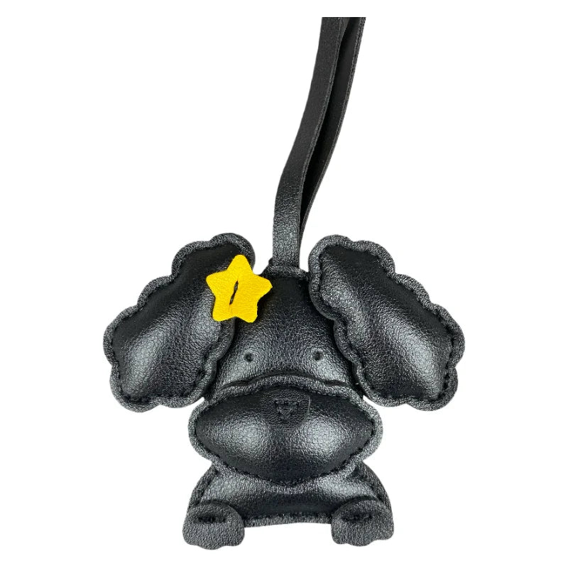 Black leather dog-shaped bag charm with a yellow star on a white background