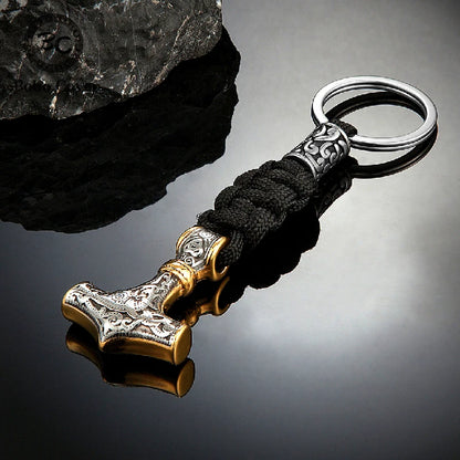 Keychain with Thor's hammer design on a reflective surface