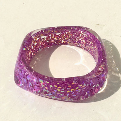 Purple glittery bangle on a light beige background