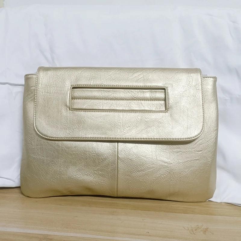 Gold clutch bag on a wooden surface with a white background