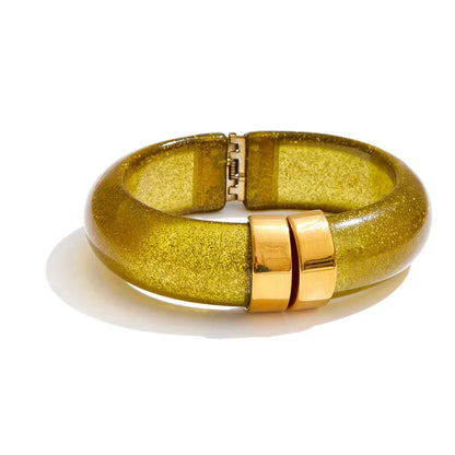 Gold bracelet with a glittery finish on a white background