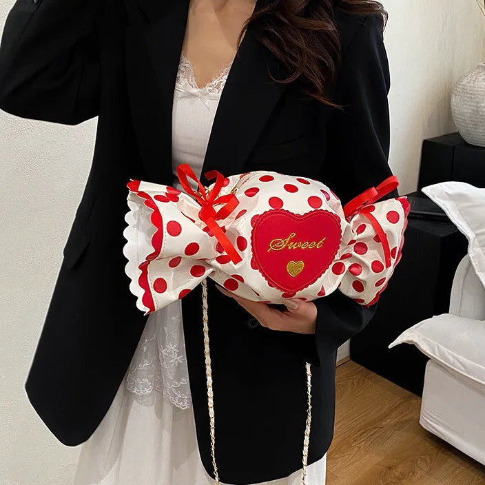 Person holding a polka dot bag with a red heart design in a room.