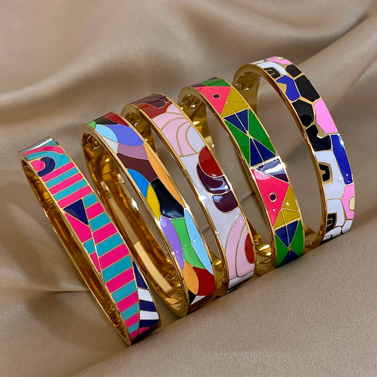 Set of colourful bangles with geometric patterns on a beige fabric background