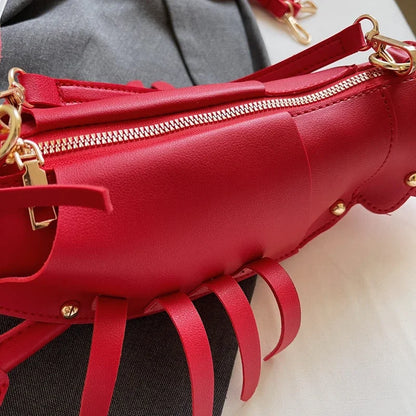 Red handbag with gold zippers and accents on a neutral background