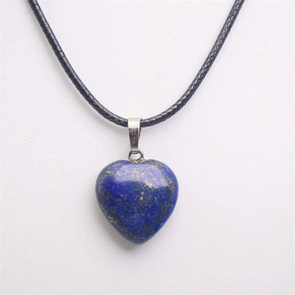 Heart-shaped lapis lazuli pendant on a black cord against a white background