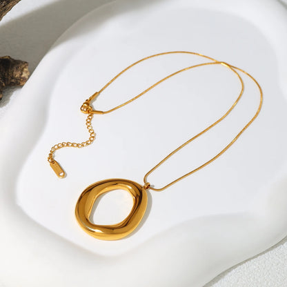 Gold necklace with a unique pendant on a white surface