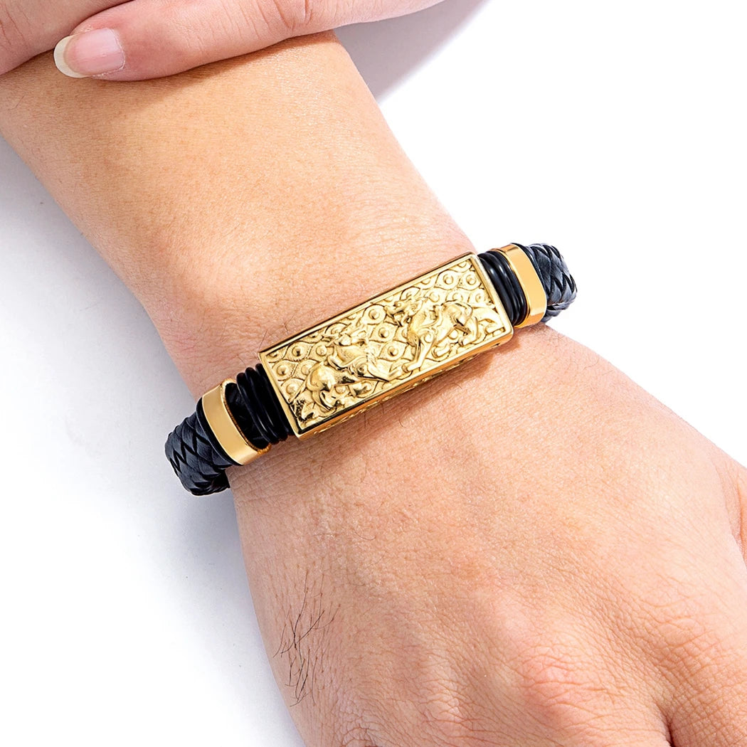 Gold and black bracelet on a wrist against a white background