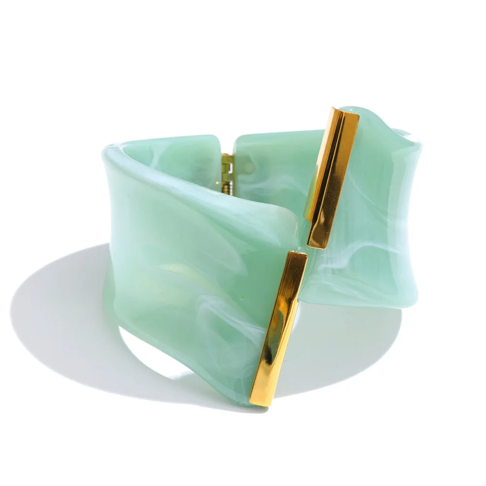 Green bracelet with gold accents on a white background