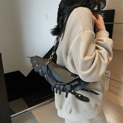 Person wearing a unique black leather bag with claw-like design.