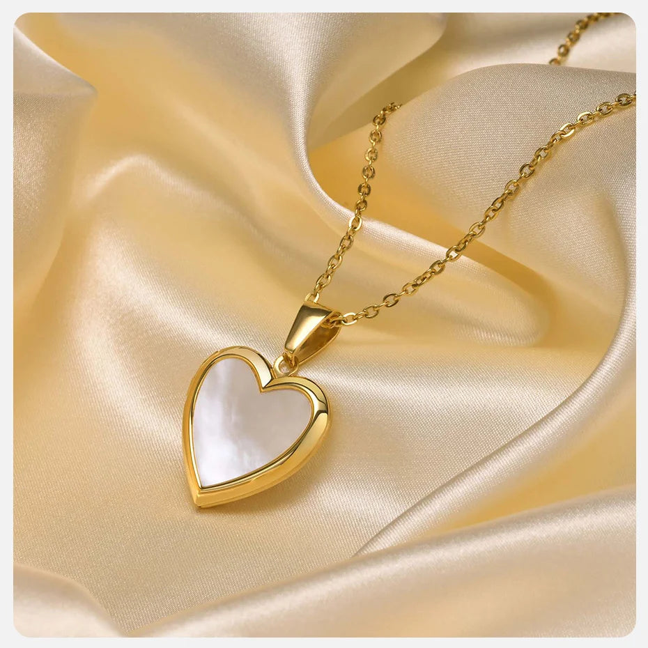 Gold heart-shaped pendant necklace on a gold satin background