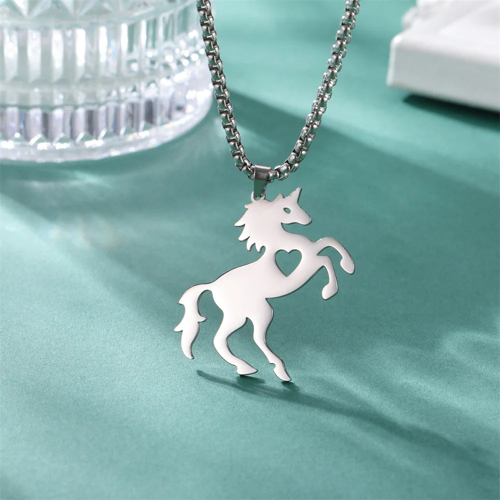 Silver horse pendant necklace on a teal fabric background