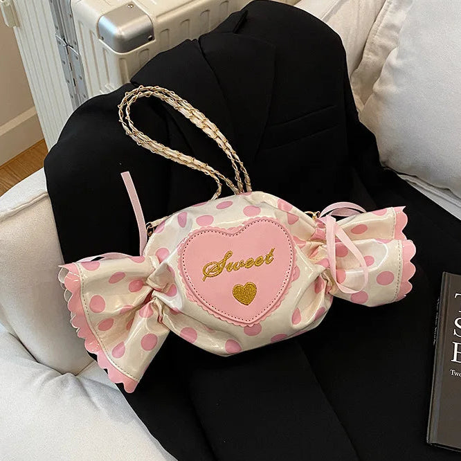 Pink polka dot candy bag with a heart and 'sweet' text on a black chair.