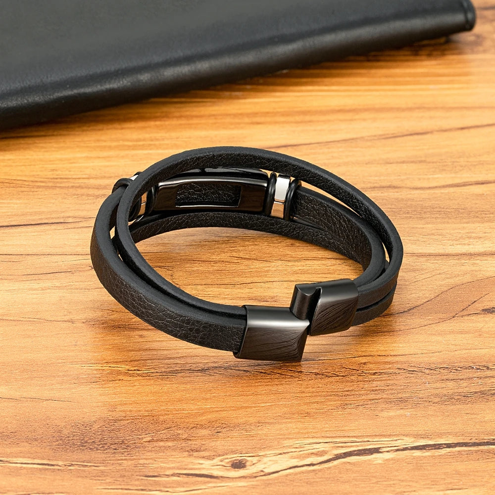 Black leather bracelet with metal clasp on a wooden surface