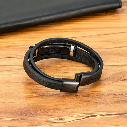 Black leather bracelet with metal clasp on a wooden surface