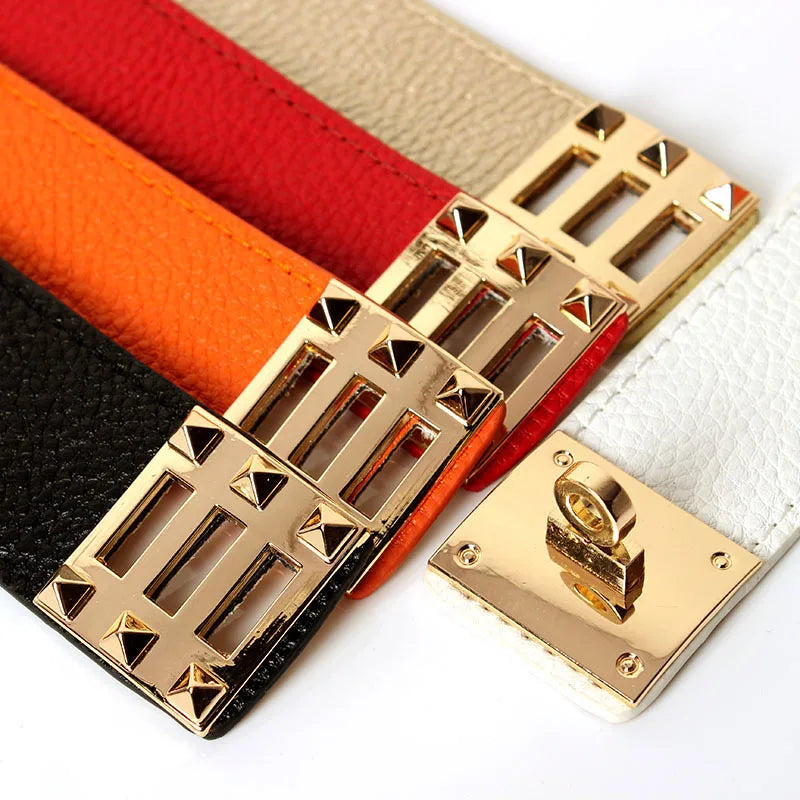 Gold buckle on a bracelet with red, orange, and black leather straps on a white background