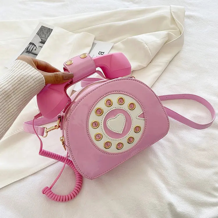 Pink phone-shaped handbag with a matching pink phone handle on a white surface