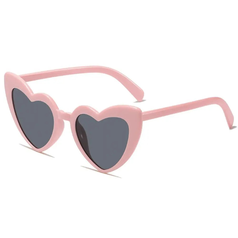 Heart-shaped pink sunglasses with dark lenses on a white background