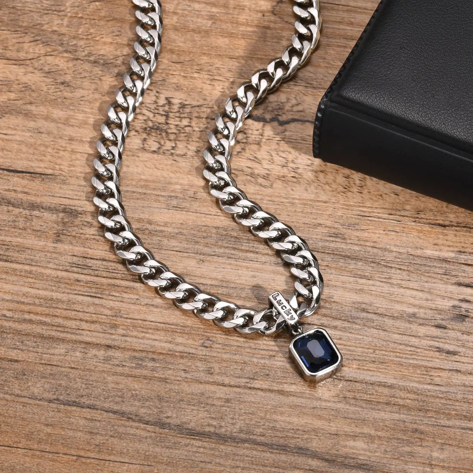 Silver chain necklace with a pendant on a wooden surface