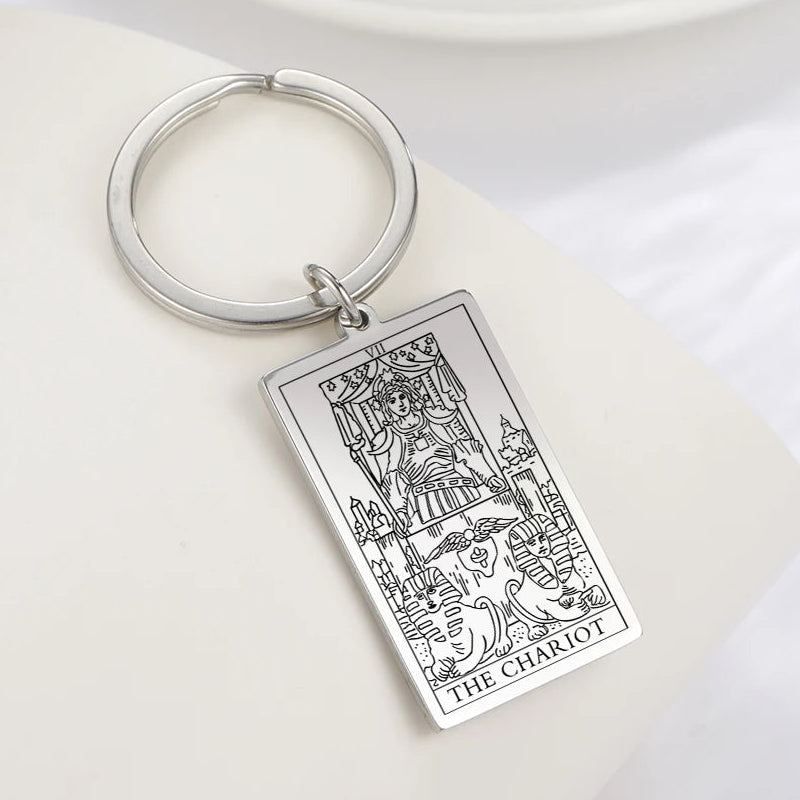 Keychain with 'The Chariot' tarot card design on a white surface