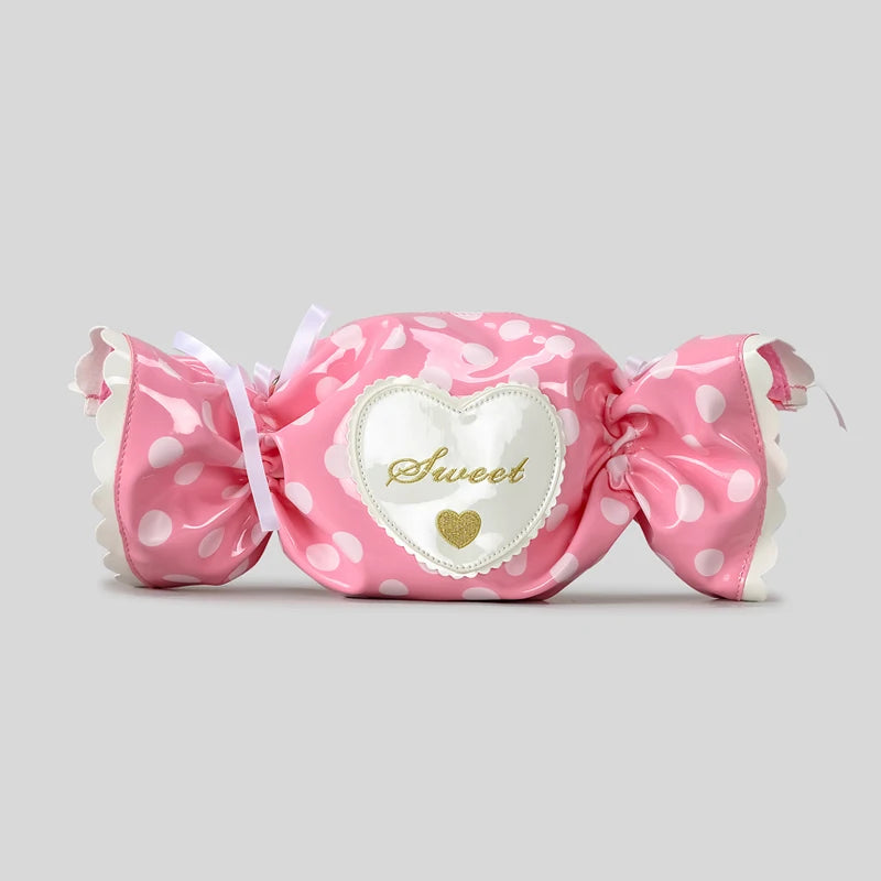 Pink polka dot candy bag with a heart-shaped label on a grey background