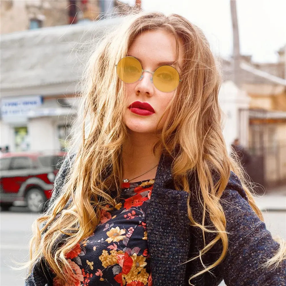 Woman wearing sunglasses and a floral top in an urban setting