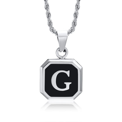 Silver necklace with a black pendant featuring the letter 'G' on a white background