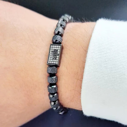 Silver beaded bracelet on a wrist with a blurred background