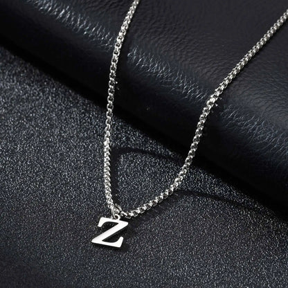 Silver necklace with a 'Z' pendant on a black textured surface