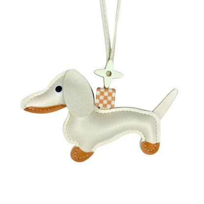 White leather dachshund shaped design bag charm with a checkered bag on a white background
