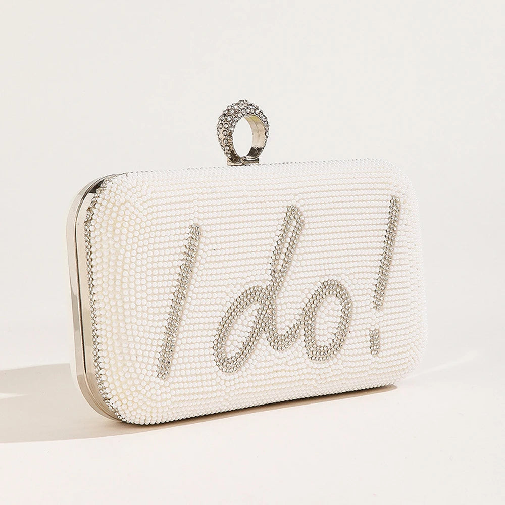 White beaded clutch with 'I do!' text on a light grey background
