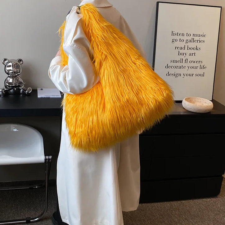 Person holding an orange fluffy bag in a room with a desk and decor items.